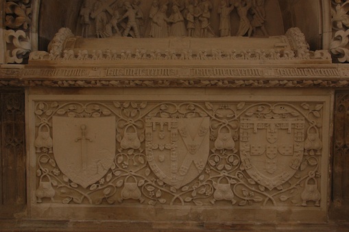 Le mot de Jean de Portugal sur sa tombe dans la chapelle royale de Batalha, associé à ses devises de l’arbousier et de la besace, à l’écu de l’ordre de Saint Jacques, aux armes parties du prince et de son épouse Isabelle de Bragance, à ses propres armes.